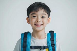 A young boy with a backpack smiling photo