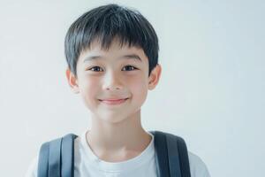 A young boy with a backpack smiling photo