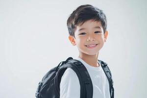 A young boy with a backpack smiling photo