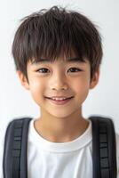 A young boy with a backpack smiling photo