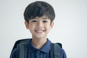 A young boy with a backpack smiling photo