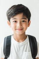 A young boy with a backpack smiling photo