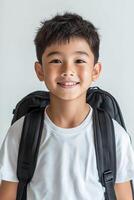 A young boy with a backpack smiling photo