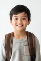 A young boy with a backpack smiling photo