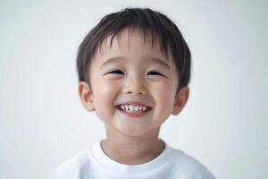 A young boy smiles while standing in front of a white background photo