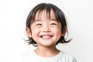 A little girl smiles while standing in front of a white background photo