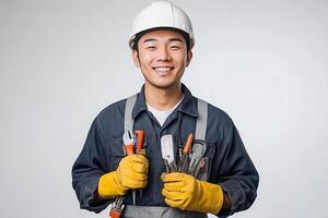 A young man in a hard hat and overalls holding a wrench photo
