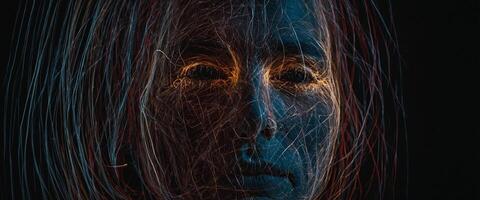 A woman's face is illuminated by light photo