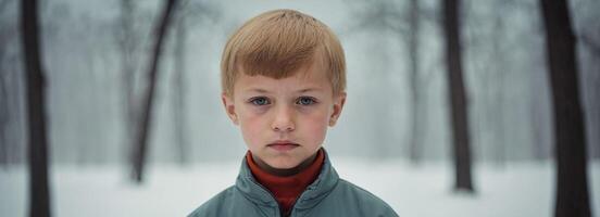 A young boy is standing in the snow photo
