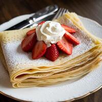 A stack of crepes with strawberries on top photo
