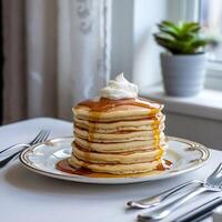 A stack of pancakes on a plate with syrup and butter photo
