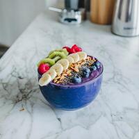 A blueberry smoothie bowl with fruit and nuts photo