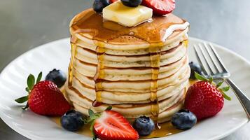 A stack of pancakes with syrup and berries photo