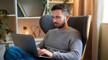 A man sitting in a chair with a laptop photo