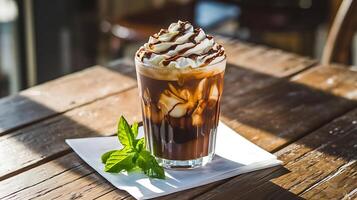An iced coffee with whipped cream and mint leaves photo