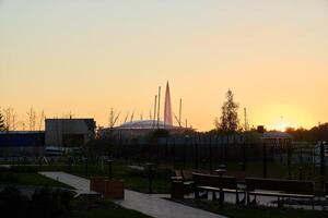 A breathtaking view of a sunset over an urban park surrounded by elegant modern architecture photo