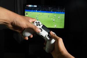 Gamer playing soccer game with a wireless controller photo