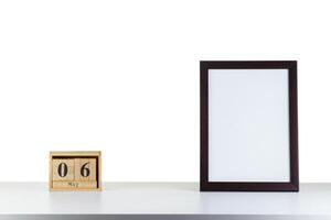 Wooden calendar 06 may with frame for photo on white table and background