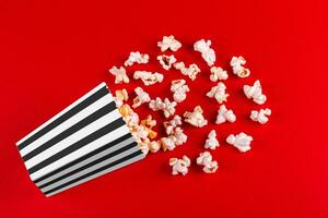 box with popcorn striped in different colors on a red background photo