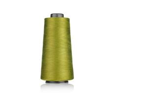 spool of industrial thread green color, texture of thread on a white background photo