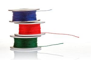 spools of thread in blue, red, green colors on a white background photo