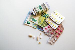 Jelly capsules and hard tablets of vitamin D on dollar bills on a white table photo