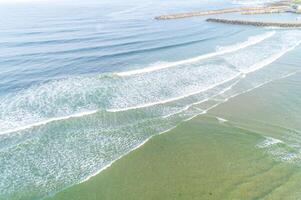 aerial drone view of a coastal portion and a harbor protected by breakwaters, background summer concept photo