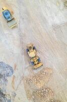 heavy machinery on a construction site, a bulldozer and a steamroller preparing the surface, aerial zenithal view with a drone. photo