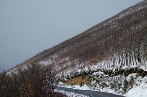 road on a snowy mountainside in the wintertime, concept of winter background photo