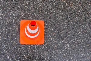 Striped orange cones on the asphalt road. Plastic orange cone on the road. Construction cones marking part of road with a layer of fresh asphalt. photo
