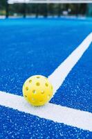 a lonely pickleball ball on the line on a pickleball court, racket sports background photo