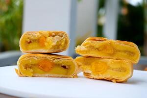 High angle view of whole and two halves chinese pastry or moon cake filled with sweet mung bean paste and salted egg yolk. photo