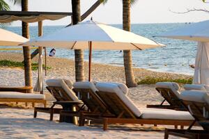 2 beach chairs and 1 beach umbrella are located to the side. photos relevant to summer holidays. shot in a vertical position