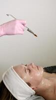 A professional beautician makes a Carboxing bone mask for the face and neck of a client of a carboxytherapy patient, close-up photo
