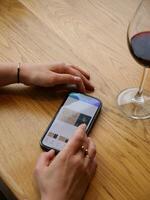 A person using an iphone to view a wine app photo