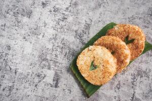 Indonesian Traditional Coconut Cake called Sagon on Banana Leaf with Rustic Background Setting photo
