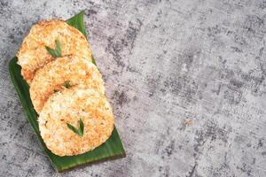 Indonesian Traditional Coconut Cake called Sagon on Banana Leaf with Rustic Background Setting photo
