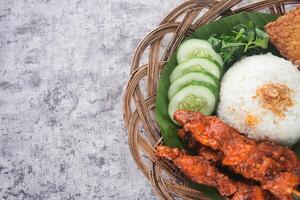 Traditional Indonesian Skewers Served with Rice and Vegetables in a Bamboo Basket photo