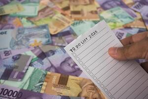Planning Financial Goals for 2025 Using a To-Do List and Currency Notes photo