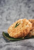 Indonesian Traditional Coconut Cake called Sagon on Banana Leaf with Rustic Background Setting photo