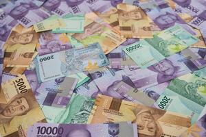 Various Colorful Indonesian Rupiah Banknotes Displayed in a Scattered Arrangement photo