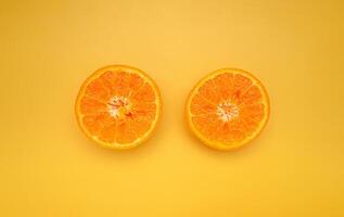Top view of sliced oranges is over a yellow background photo