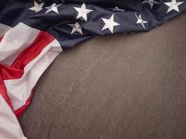 The American flag is on a black stone pattern background with copy space for text photo
