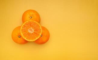 Top view of fresh oranges over a yellow background photo