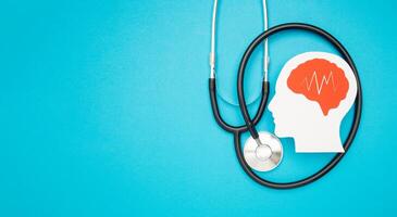 A brain shape made from paper and a stethoscope on a light blue background photo