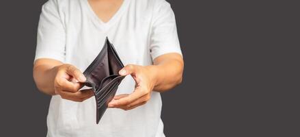 A man hands open an empty wallet standing on a gray background photo