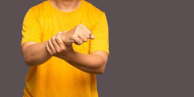 Close-up of hands male suffering from wrist pain while standing on a gray background photo