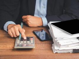 Businessman uses a calculator to calculate the company's financial results in the office and tax, accounting, statistics, and financial analysis while sitting in the office photo