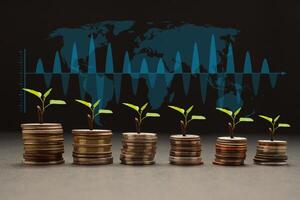 Business investment profit and dividend money from saving concept. Tree growing on a pile of coins money with a world map and graph background photo