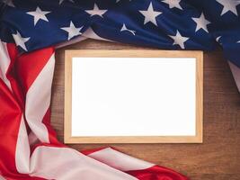 Top view of the American flag and empty mini whiteboard over a wooden table photo